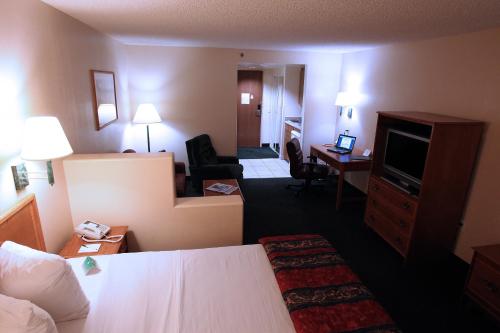 a hotel room with a bed and a living room at Gateway Studio Suites in Sierra Vista