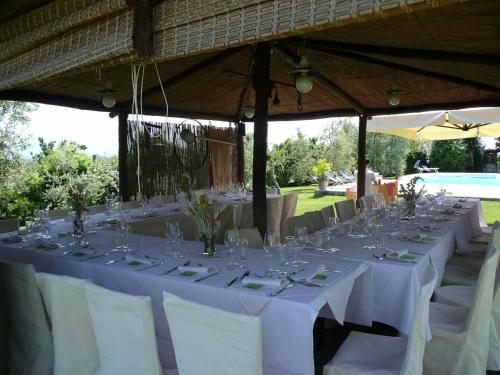 a table set up for a wedding with white tables and chairs at Il Baraccotto in Lucignano