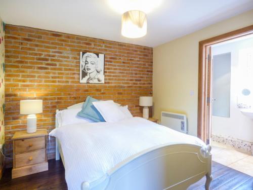 a bedroom with a brick wall and a bed at Blue Oyster in Mullion