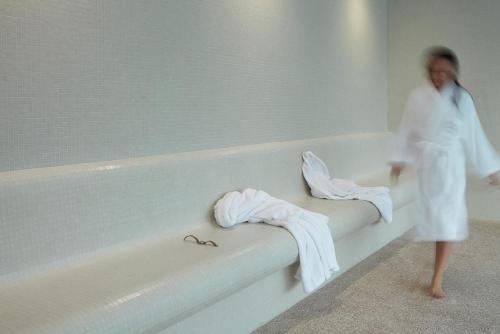 a woman in a bath room with towels on a bath tub at Abrigo da Montanha Hotel Rural in Sabugueiro