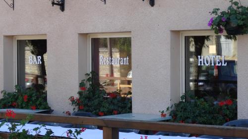 a store front with three windows with flowers in it at Sarl Macarena in Pouillenay