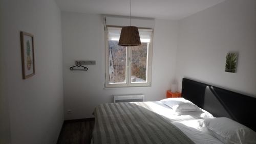 a bedroom with a bed and a window at KAYSERSBERG -Alsace- APPARTEMENTS -CENTRE HISTORIQUE in Kaysersberg