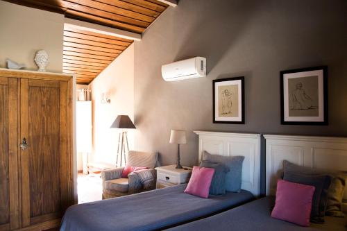a bedroom with a bed with pink and blue pillows at Herdade das Barradas da Serra in Grândola