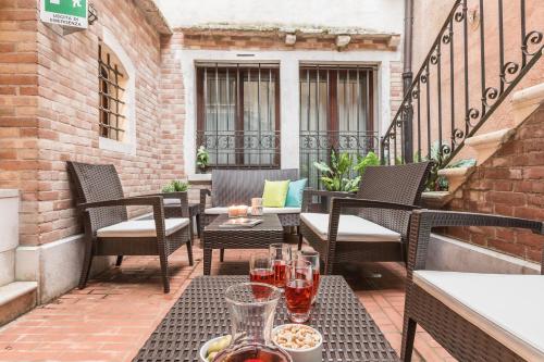 a patio with chairs and tables on a balcony at Ca' Del Monastero 8 Collection Apartment for 3 Guests in Venice