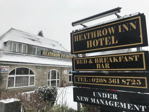 a group of street signs in front of a hotel at Heathrow Inn Hotel in Hillingdon