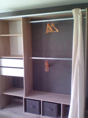 a closet with some shelves and a curtain at Dolce Casa in Sainte-Foy-lès-Lyon
