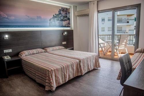 a hotel room with a bed and a balcony at Hotel Prado II in Peniscola