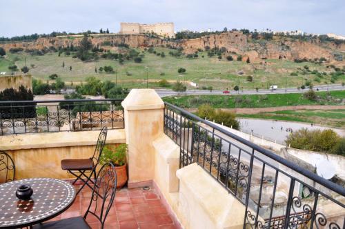 a balcony with a table and chairs and a view at Riad Ahlam in Fès