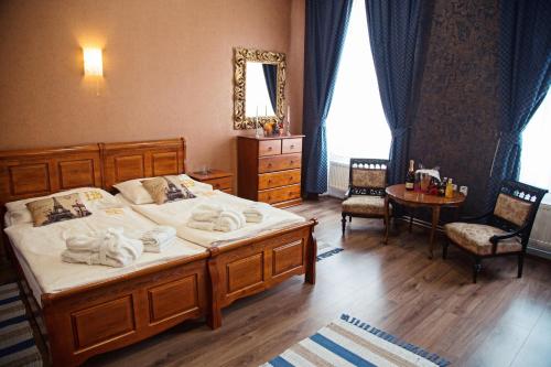 a bedroom with two beds and a table and a mirror at Hotel Bristol in Banská Štiavnica