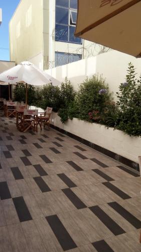 an outdoor patio with tables and an umbrella at Hotel Diego de Almagro Curicó in Curicó