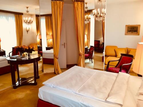 a bedroom with a bed and a living room at Hotel Opera in Munich