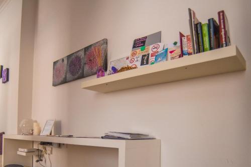a shelf on a wall with books on it at Zer051 Apartment Dossetti 23 in Bologna