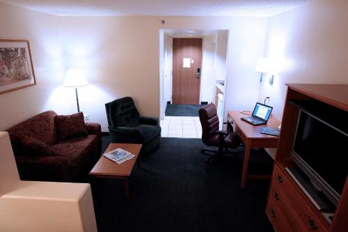 a hotel room with a desk and a living room at Gateway Studio Suites in Sierra Vista