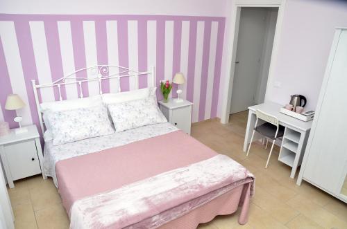 a pink and white bedroom with a bed and a desk at IL CILIEGIO Affittacamere in Stresa