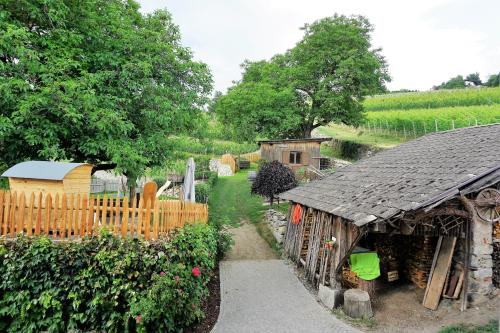 a garden with a wooden fence and a building at BUEHLERHOF Agriturismo, Obst-&Weingut, Urlaub mit Hund, Bauernhof, Brixen in Rosa