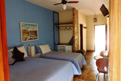 a bedroom with two beds and a ceiling fan at Fazenda Hotel Pedra dos Ventos in Quixadá