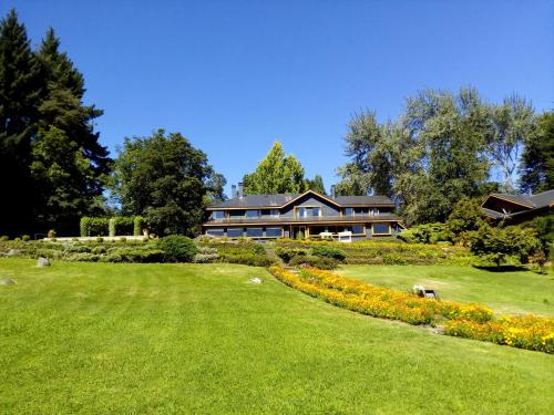 a large house with a large lawn in front of it at Hotel y Cabañas El Parque in Villarrica