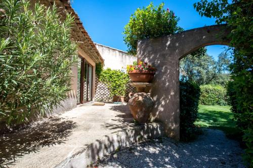 an archway leading to a house with a pot of flowers at La Ferme in Saint-Marc-Jaumegarde