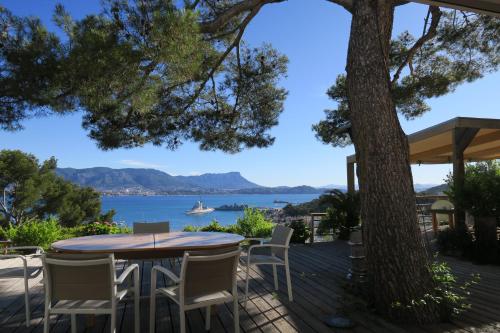 une table et des chaises sur une terrasse avec vue sur l'eau dans l'établissement Home6, à Saint-Mandrier-sur-Mer