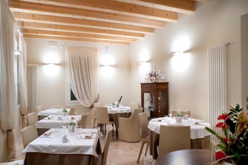 a restaurant with tables and chairs with white tablecloths at Locanda ai Capitelli snc di fiumicetti andrea in Soave