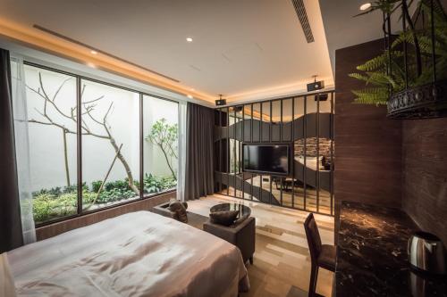 a bedroom with a bed and a large window at Green Palm Motel in Yuanlin