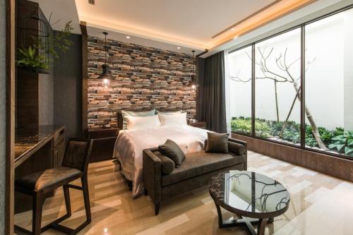 a bedroom with a bed and a couch and a table at Green Palm Motel in Yuanlin