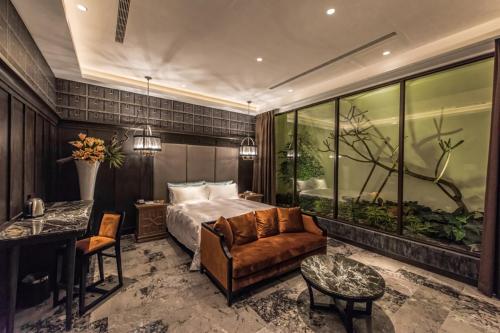 a bedroom with a bed and a couch and a table at Green Palm Motel in Yuanlin