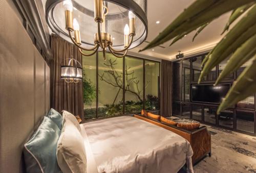 a bedroom with a bed and a chandelier at Green Palm Motel in Yuanlin