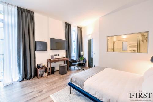 um quarto de hotel com uma cama e uma secretária em La Spezia by The First - Luxury Rooms & Suites em La Spezia