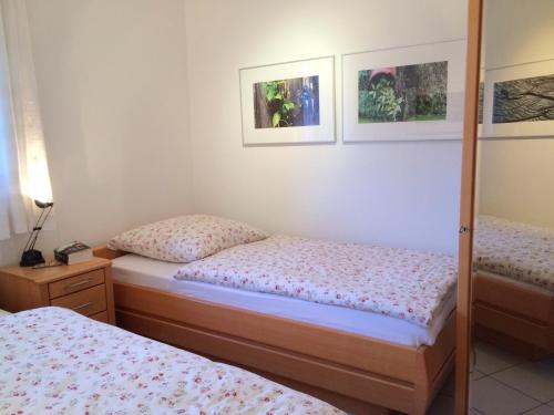 een slaapkamer met 2 bedden en een spiegel bij Haus Roland Wohnung 32 in Zinnowitz