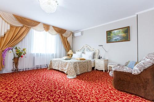 a room with a bed, table and a rug at Grand Hotel Uyut in Krasnodar