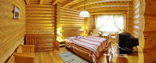 1 dormitorio en una cabaña de madera con cama y escritorio en Marika, en Dragobrat