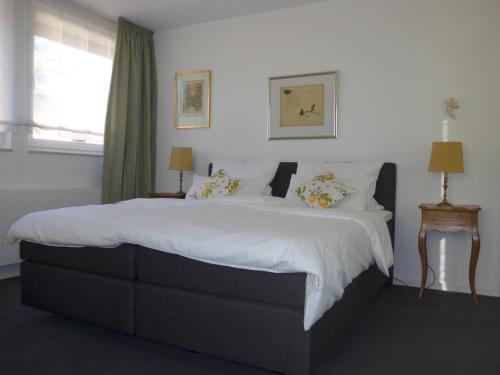 a bedroom with a large bed with white sheets and pillows at Apartment Oberwerth in Koblenz