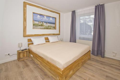 Schlafzimmer mit einem Bett und einem Fenster in der Unterkunft Haus Nordstrand - Tolle Ferienwohnung Ostseebad Göhren in Göhren
