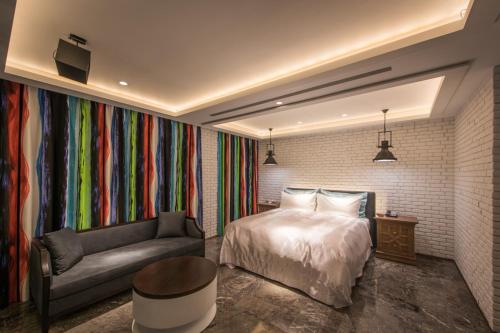 a bedroom with a bed and a couch at Green Palm Motel in Yuanlin