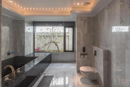 a bathroom with a toilet and a sink and a window at Green Palm Motel in Yuanlin