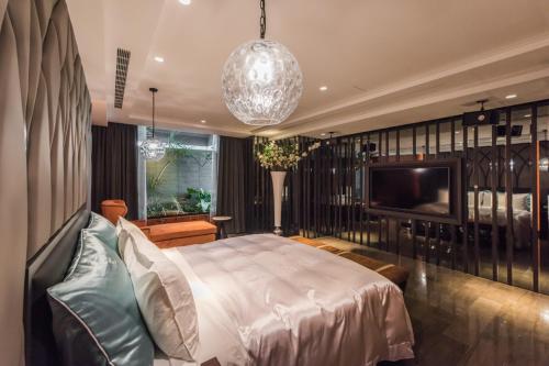 a bedroom with a bed and a flat screen tv at Green Palm Motel in Yuanlin