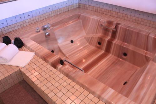 a wooden tub in a bathroom with a tiled floor at Motel Des Pays D'En Haut in Val-David