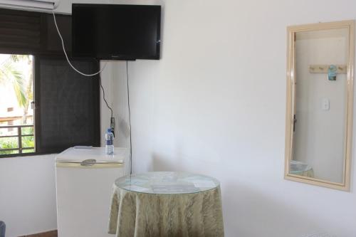 einen kleinen Tisch in einem Zimmer mit Kühlschrank in der Unterkunft Pousada Volare in Matinhos
