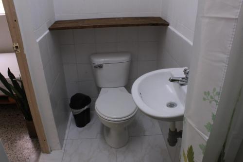 a small bathroom with a toilet and a sink at Hostal Paz y Vida in Medellín