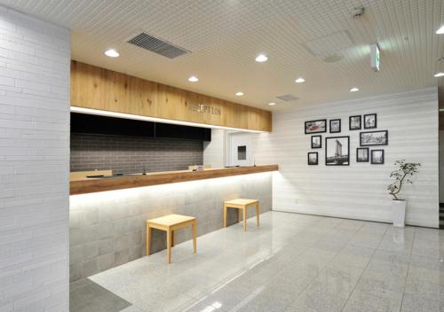 a lobby with a counter and two stools at Hotel JIN Morioka Ekimae in Morioka