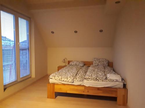 a bedroom with a bed and a large window at Útulný apartmán v Bratislava 15 in Bratislava