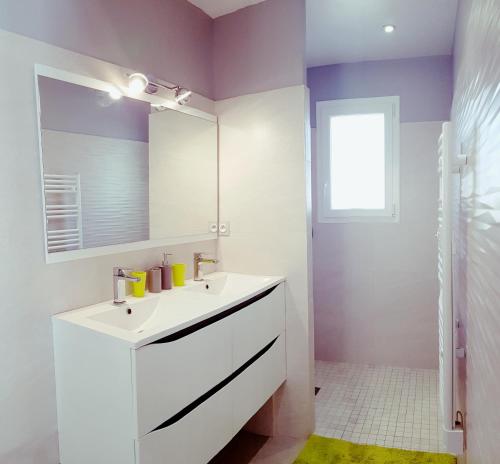 een badkamer met een witte wastafel en een spiegel bij Le Mas Sophil in Carcès