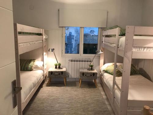 Cette chambre comprend 2 lits superposés et une fenêtre. dans l'établissement Elan Apartment, à Elantxobe