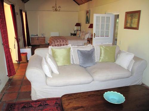 a living room with a white couch and a bed at High Hopes in Greyton