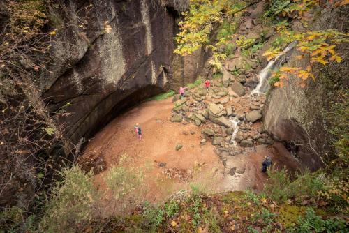 a group of people standing on rocks near a waterfall at Howe of Torbeg in Ballater