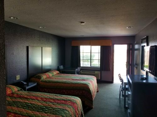 a hotel room with two beds and a desk at Executive Inn Pasadena in Pasadena