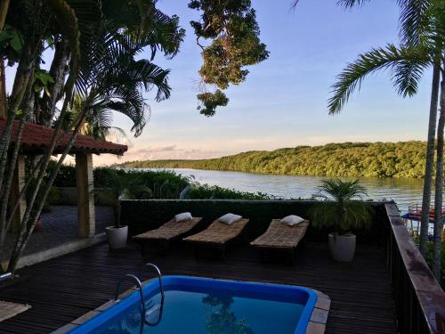 a resort with a pool and a view of a river at Pousada Canto do Rio in Prado