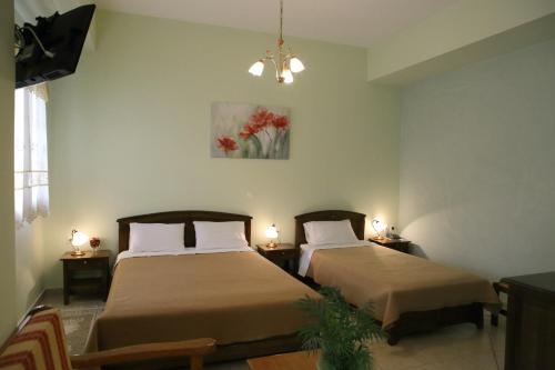 2 camas en una habitación con 2 lámparas en las mesas en Mani Hotel, en Areopoli