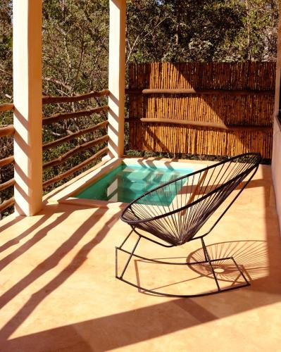 a chair sitting on a patio next to a pool at Casa Mono in San Agustinillo